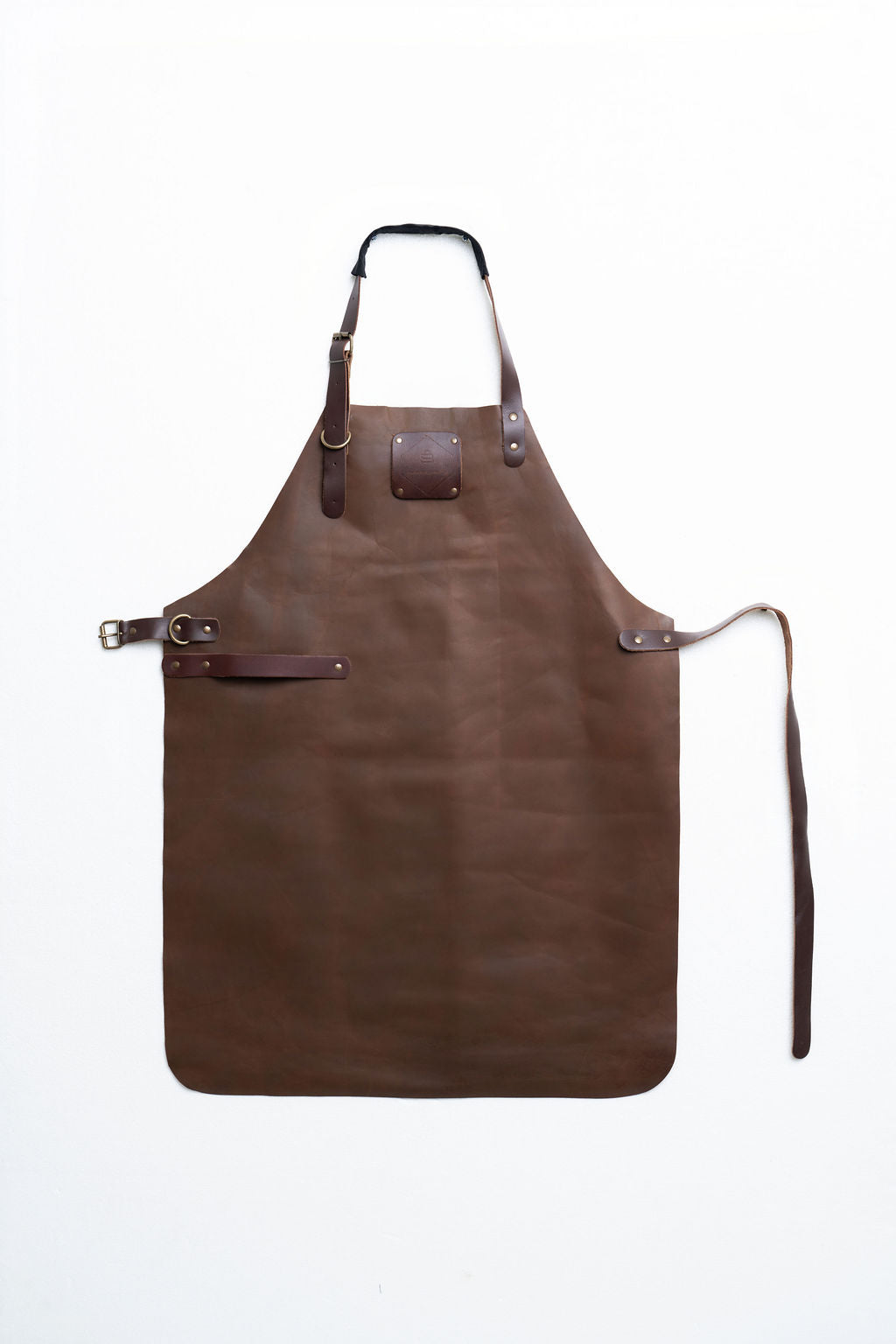 Full-length brown leather apron with adjustable straps and metal buckles on a white background