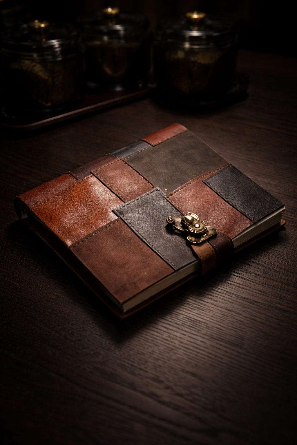 Premium leather patchwork notebook displayed on wooden desk with antique décor.