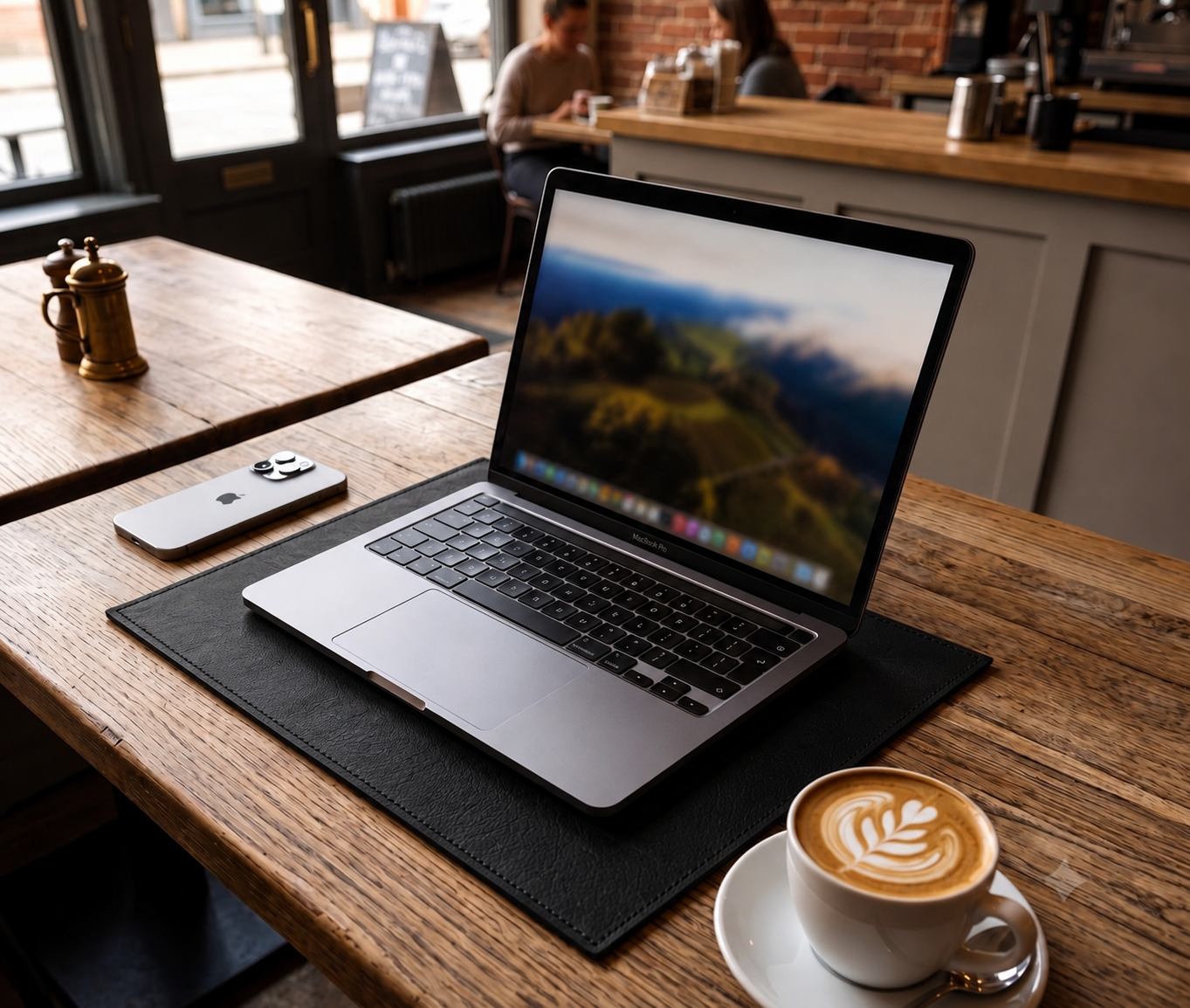 Laptop on a wooden table with a cup of coffee and smartphone in a cafe setting